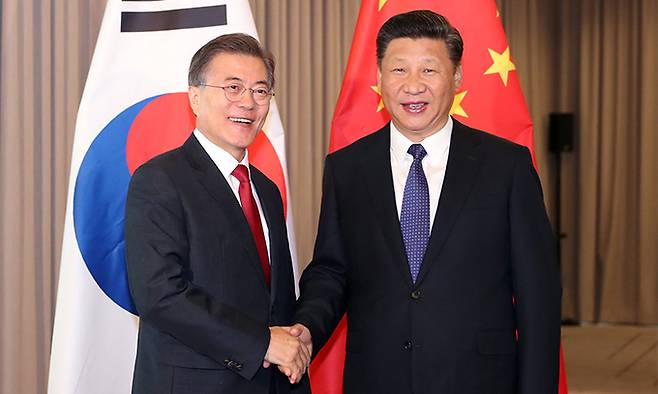 2017년 문재인 대통령(왼쪽)과 시진핑 중국 국가주석이 베를린 인터콘티넨탈 호텔에서 열린 한·중 정상회담에서 악수하며 미소짓고 있다. 뉴시스