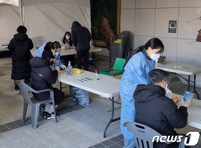 29일 신속항원검사가 시행된 천안시청 임시선별진료소에서 시민들이 자가진단키트를 이용해 코로나19 검사를 하고 있다.© 뉴스1