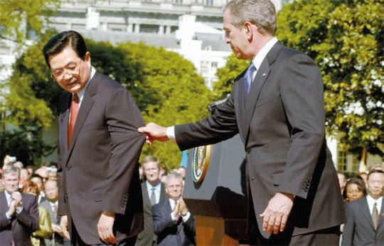 2006년 4월 워싱턴 백악관에서 열린 후진타오 중국 주석 환영식에서 조지 W 부시 당시 대통령이 식이 끝났다고 착각해 단상을 떠나려는 후 주석의 소매를 잡아당기는 모습. AP=연합뉴스.