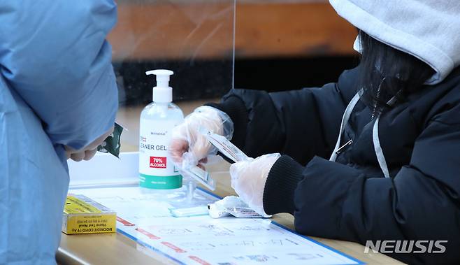 [서울=뉴시스] 조수정 기자 = 29일 오전 서울 종로구 보건소 코로나19 선별진료소 신속항원 검사소에서 시민이 자가진단키트로 검사를 하고 있다.  설 연휴 첫날인 이날 0시기준 코로나19 신규 확진자는 1만 7542명으로 연일 역대 최다를 경신하고 있다. 서울시는 오미크론 확산 대비 검사인원 수용을 위해 29일부터 보건소 25곳과 직영 검사소 4곳에서 신속항원검사용 자가진단키트를 무료 제공한다. 오는 3일부터는 60세 이상 고위험군을 제외하고는 모두 자가진단키트를 사용해야 한다. 2일까지는 PCR검사와 자가진단키트 중 선택할 수 있다.  2022.01.29. chocrystal@newsis.com
