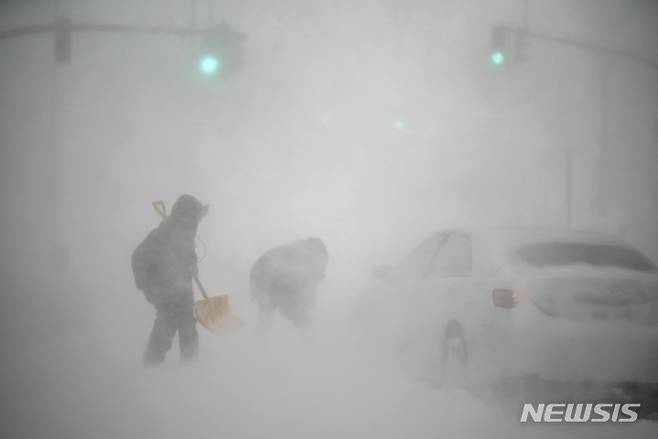 [프로비던스(미 로드아일랜드주)=AP/뉴시스]미 로드아일랜드주 프로비던스에서 29일(현지시간) 폭설로 발이 묶인 운전자 한 명이 삽을 든 행인의 도움을 받고 있다. 허리케인급의  돌풍을 동반한 폭풍이 29일 미 동북부 지역을 강타해 45㎝가 넘는 폭설이 쏟아지고, 해안가에 홍수가 발생했으며 광범위한 정전이 발생할 수 있다고 예보됐다. 기상 예보관들은 상황이 더 악화되고 매서운 추위가 뒤따를 것이라고 경고했다. 2022.1.30