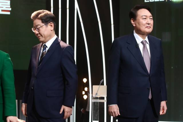 3일 서울 여의도 KBS 공개홀에서 열린 방송 3사 합동 초청 '2022 대선후보 토론'에서 이재명 더불어민주당 대선 후보(왼쪽)가 기념촬영을 마친 뒤 자리로 돌아가고 있다. 오른쪽은 윤석열 국민의힘 대선 후보./권욱 기자