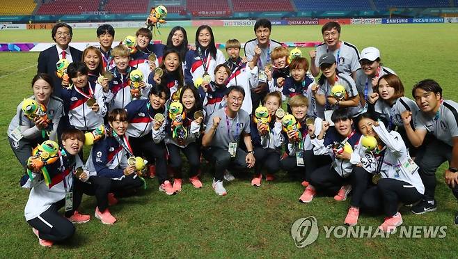 3회 연속 AG게임 동메달 획득한 여자축구팀 (팔렘방=연합뉴스) 김도훈 기자 = 2018년 8월 31일(현지시간) 인도네시아 팔렘방 자카바링 스포츠 시티 겔로라 스리위자야 경기장에서 열린 2018 자카르타-팔렘방 아시안게임 여자축구 시상식에서 동메달을 획득한 선수들과 윤덕여 감독을 비롯한 코치진 및 관계자들이 기념촬영을 하고 있다. 2018.9.1 superdoo82@yna.co.kr