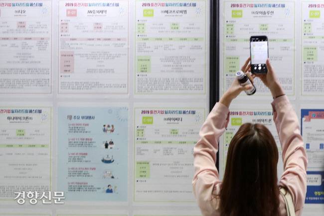 중견기업 일자리 드림 페스티벌에 참가한 구직자가 핸드폰으로 채용공고를 촬영하고 있다. 경향DB