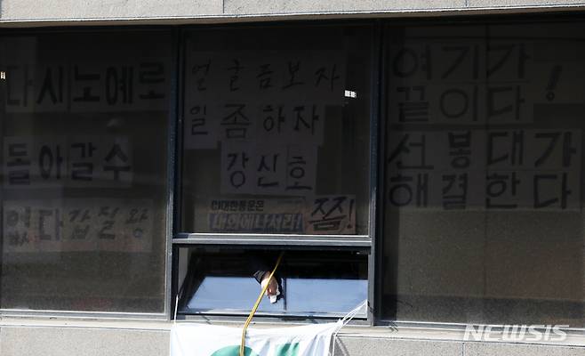 [서울=뉴시스] 조성우 기자 = 16일 오전 서울 중구 CJ대한통운 본사에서 점거 농성중인 전국택배노동조합 조합원이 창문을 닦고 있다. 2022.02.16. xconfind@newsis.com