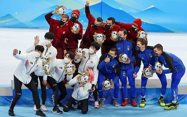 16일 중국 베이징 캐피털 실내 경기장에서 열린 2022 베이징 동계올림픽 쇼트트랙 남자 5000m 계주 결승가 끝난 플라워세리머니에서 메달을 수상한 한국(왼쪽부터), 캐나다, 이탈리아 선수들이 셀피 촬영을 하고 있다. (사진=연합뉴스)