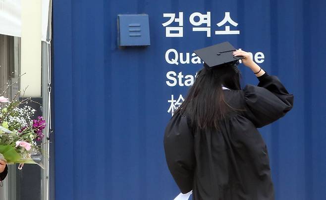 14일 오후 중앙대 서울캠퍼스에서 열린 학위수여식에서 학사모를 쓴 졸업생이 코로나19 검사소를 지나고 있다. /연합뉴스