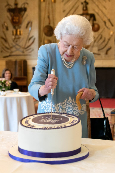 엘리자베스 2세 영국 여왕이 즉위 70주년 하루 전인 5일(현지시간) 샌드링엄 별장에서 열린 축하 행사에서 케이크를 자르고 있다. 여왕은 이날 조촐한 기념식을 가졌다.샌드링엄 로이터 연합뉴스