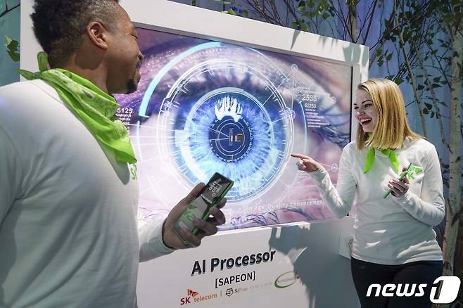 SK텔레콤이 미국 라스베이거스에서 열리는 'CES 2022'에서 넷-제로(Net-zero) 시대의 그린 ICT 기술을 선보인다고 5일 전했다. 모델들이 AI 반도체 '사피온(SAPEON)'을 소개하고 있다. (SK텔레콤 제공) 2022.1.5/뉴스1