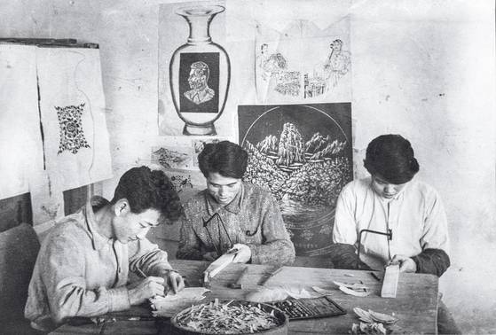 A photograph of North Korean craftsmen working on the gifts Kim Il Sung gave to Stalin, which was included in the catalogue booklet. [KIM HYUN-DONG]