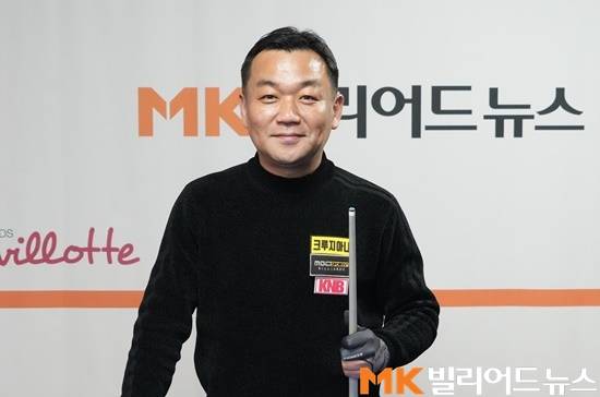 큐를 들고 카메라를 향해 포즈를 취하고 있는 김위원.