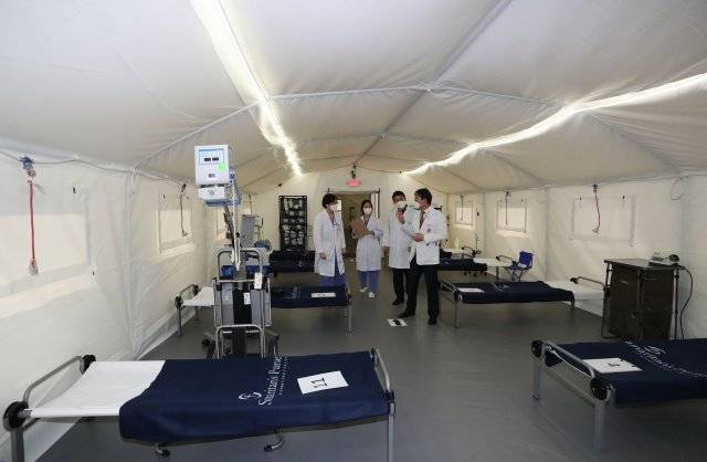 24일 서울 성북구 고려대학교 화정체육관에 설치된 긴급모듈병원을 고려대병원 이성우 응급의료센터장(오른쪽에서 첫 번째)과 의료진들이 살펴보고 있다. 긴급모듈병원은 고려대학교의료원과 서울시, 국제구호단체 사마리안퍼스가 코로나19의 확산에 따른 병상부족과 감염병 대응을 위해 구축했다.