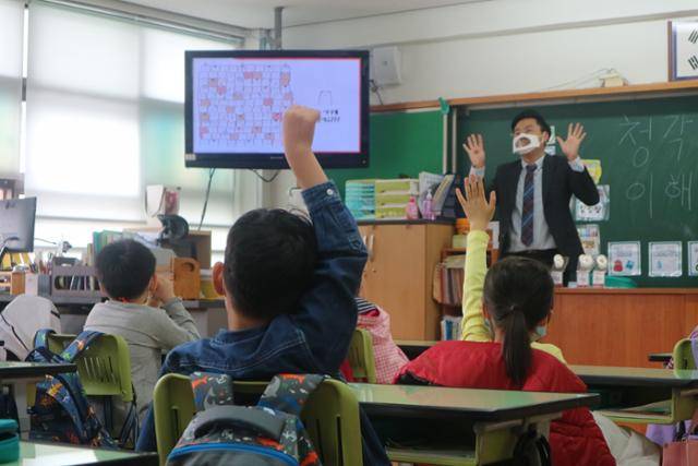 청각장애인을 지원하는 사단법인 '사랑의 달팽이'의 이인환 과장이 2020년 6월 서울의 한 초등학교에서 '청각장애 이해교육'을 진행하고 있다. 청각장애인 아동도 수업 내용을 잘 이해할 수 있도록 강사가 입 모양이 보이는 투명 마스크를 착용하고 있다. 사랑의 달팽이 제공