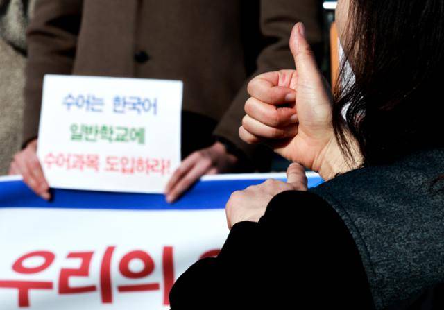 지난해 11월 24일 서울 영등포구 여의도 국회 앞에서 열린 '감각장애인 선거공약연대 출범 기자회견'에서 수어통역사가 여야 대선 후보의 장애인 공약 수립과 이행을 촉구하는 메시지를 통역하고 있다. 연합뉴스