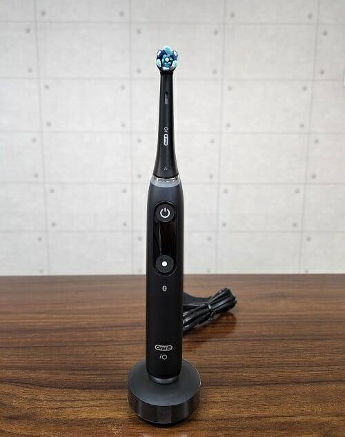 오랄비 전동칫솔 iO 시리즈9. 자석형 충전기 위에 칫솔을 세워둔 모습. (사진=지디넷코리아)