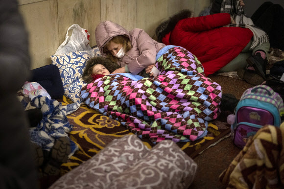 아이를 먼저 챙기는 엄마 - 우크라이나 시민들이 키예프 지하철역에서 잠을 청하고 있다. 2022.02.26 AP 연합뉴스