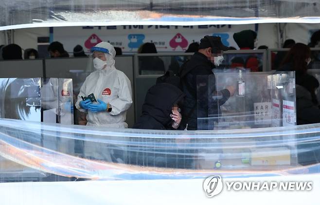 2월 23일 오전 서울 송파구보건소 선별진료소에서 시민들이 신속항원검사를 하고 있다.  중앙방역대책본부는 이날 0시 기준으로 확진자가 17만1452명 늘었다고 밝혔다. [연합뉴스 자료사진]