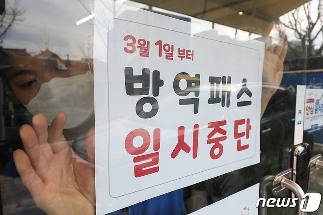 28일 오후 대구 중구의 한 음식점 유리문에 식당 직원이 3월 1일부터 시행되는 방역패스 일시중단 관련 안내문을 붙이고 있다. 2022.2.28/뉴스1 © News1 공정식 기자