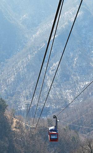 가파른 능선을 오르내리는 백암산 케이블카. 여러 대의 캐빈이 순환하는 곤돌라 형식이 아니라, 46인승 케이블카 2대가 반대쪽에서 함께 움직이며 사람들을 실어나르는 방식이다.