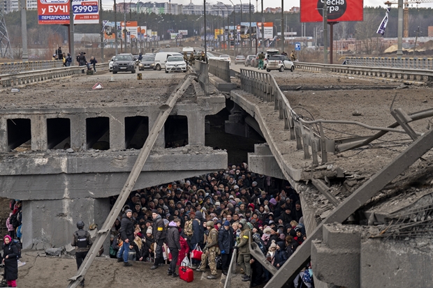 5일(현지시간) 우크라이나 키이우 외곽 이르핀강을 건너려는 피란민이 무너진 다리 밑에 피신해 있다./AP 연합뉴스