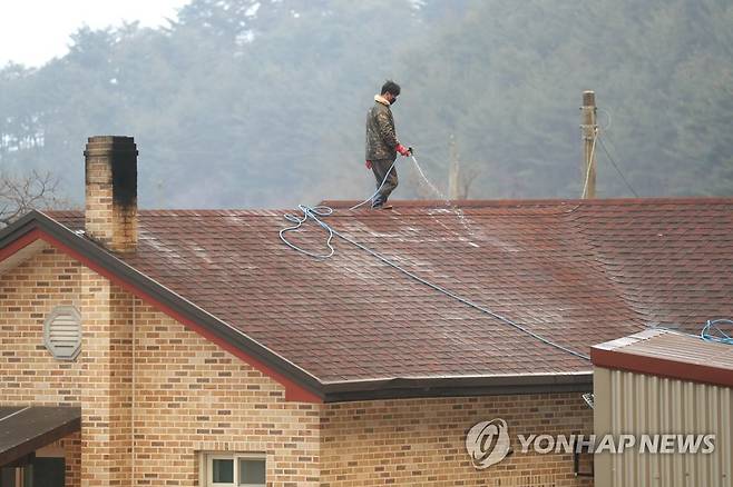 산불 대비하는 울진 주민 (울진=연합뉴스) 김현태 기자 = 울진·삼척산불 사흘째인 6일 오후 경북 울진군 울진읍 신림리 일대에서 한 주민이 산불이 다가오자 지붕에 물을 뿌리며 대비하고 있다. 2022.3.6 mtkht@yna.co.kr