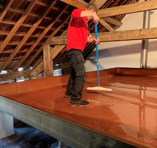 한 양조사가 실내 수영장 모양의 공간인 쿨십(Coolship)을 청소하고 있다. 쿨십은 람빅 양조 과정에서 빼놓을 수 없는 것으로 이곳에 맥즙을 넣고 공기에 최대한 노출해 발효시킨다. 지효준