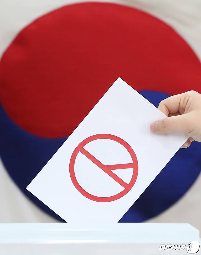 제20대 대통령선거를 하루 앞둔 8일 오후 경기 수원시의 한 투표소에서 관계자가 투표 독려 퍼포먼스를 하고 있다. 2022.3.8/뉴스1 © News1 김영운 기자