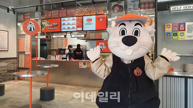 ▲신세계푸드가 10일 문을 연 노브랜드 피자 1호점 대치점 매장 내부와 브랜드 마스코트 ‘피버’. (사진=백주아 기자)