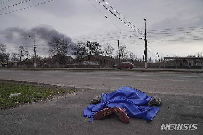 [마리우폴=AP/뉴시스] 8일(현지시간) 우크라이나 마리우폴 거리에 시신 한 구가 방수포로 덮인 채 놓여 있다. 2022.03.09.