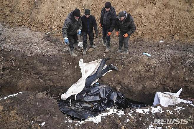 [마리우폴=AP/뉴시스] 9일(현지시간) 우크라이나 마리우폴 외곽에서 주민들이 러시아군의 포격으로 숨진 사람들의 시신을 집단 매장하고 있다. 마리우폴은 일주일 전부터 전기와 수도가 끊긴 것으로 알려졌다. 2022.03.10.