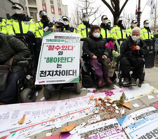 박경석 전국장애인차별철폐연대 상임공동대표가 14일 윤석열 대통령 당선인 집무실 인근에서 열린 인수위 장애인 권리예산 반영 촉구 기자회견에서 면담 및 자료 전달이 무산되자 축하난을 던지고 있다. 연합뉴스