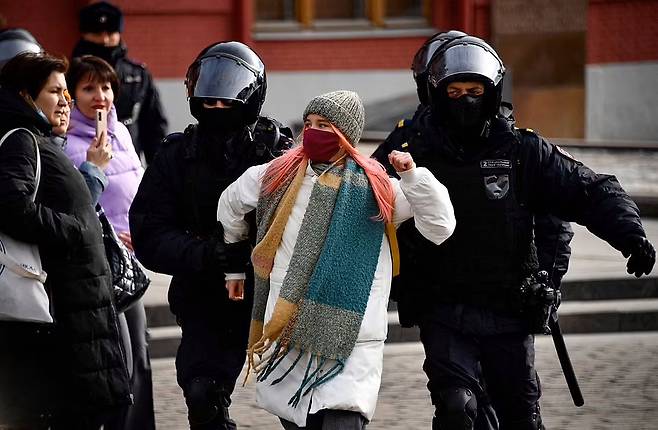 러시아 수도 모스크바의 마네즈나야 광장에서 지난 13일(현지시간) 반전 시위에 참가한 한 여성이 2명의 경찰에게 연행되고 있다.(사진=AFP 연합뉴스)