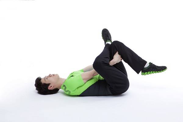 누워서 다리 꼬아 팔로 당기기/사진=인천나누리병원 제공