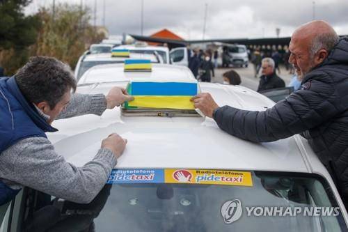 우크라이나 국기 달고 달리는 스페인 택시 기사 스페인 마드리드 택시 기사들이 지난 3월 11일(현지시간) 러시아가 침공한 우크라이나를 탈출해 폴란드에 머무는 난민들을 데리러 가는 택시에 우크라이나 국기를 붙이고 있다. EPA=연합뉴스 자료사진. 재판매 및 DB 금지]