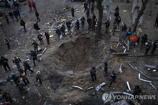 러군 폭탄 공격으로 키이우에 생긴 거대한 구덩이 (키이우 AP=연합뉴스) 20일(현지시간) 우크라이나 수도 키이우(키예프) 주민들이 러시아군의 폭탄 공격으로 생긴 거대한 구덩이 주변에 모여 있다. 러시아군이 지난달 24일 우크라이나를 침공한 뒤 공세를 강화하면서 사상자와 민간시설 피해가 급증하고 있다. 2022.3.21 leekm@yna.co.kr