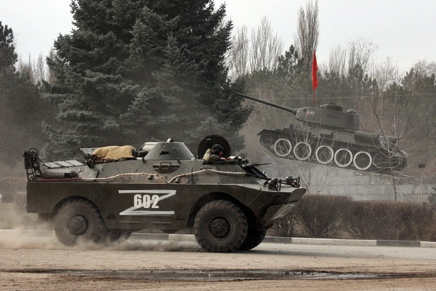 ‘Z‘가 칠해진 러시아 장갑차가 소련 시대 전차를 전시한 기념비를 지나가고 있다./로이터 연합뉴스