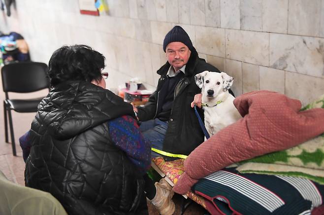21일(현지 시각) 우크라이나 하르키우의 한 지하철역으로 대피한 주민과 그 애완견이 휴식을 갖고 있다. 우크라이나 경찰은 러시아군의 포격 대상이 될 수 있다는 이유로 현지 취재진에 역 이름을 공개하지 말아줄 것을 요청했다./EPA 연합뉴스