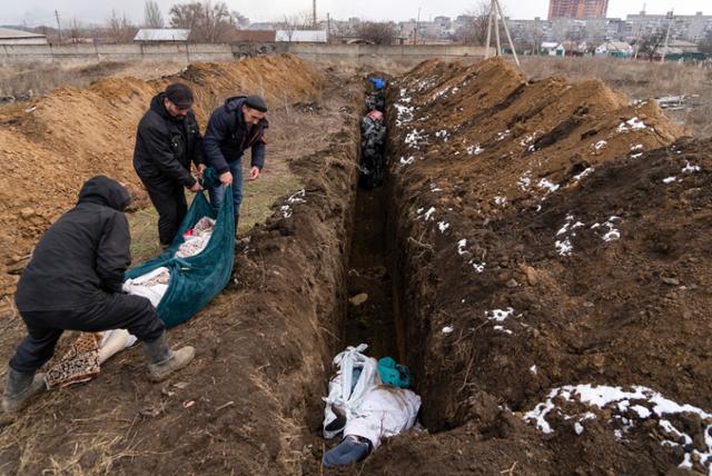 러시아군의 집중 폭격으로 초토화된 우크라이나 동남부 마리우폴에서 주민들이 9일 희생자들을 집단 매장하고 있다. 마리우폴=AP 연합뉴스