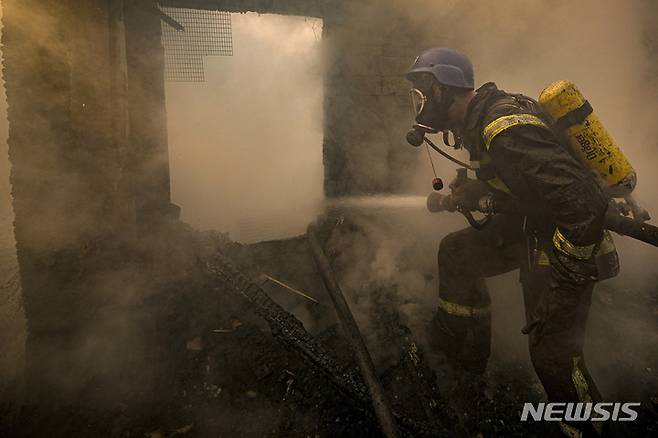 [키이우=AP/뉴시스] 23일(현지시간) 우크라이나 키이우에서 한 소방관이 포격으로 파괴된 집 안의 불을 끄고 있다. 현지 관계자는 러시아군이 전날 밤과 23일 새벽 키이우 시 스비아토신스키와 셰브첸키브스키 지역을 포격해 건물들을 파괴했다고 밝혔다. 2022.03.23.