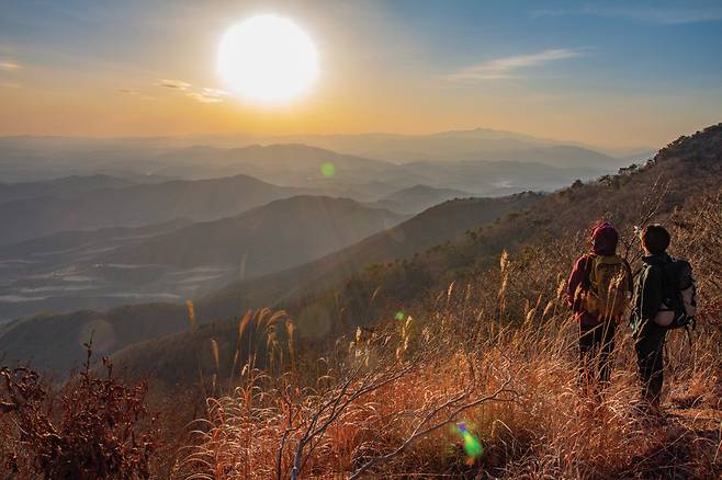 자굴산 정상부에서 바라본 지리산 일몰. 손으로 가리키는 곳이 지리산 천왕봉(우측 제일 높은 봉)이며, 그 앞쪽 산줄기가 산청의 웅석봉(1,099m)이다. 실로 광대한 조망이 아닐 수 없다.