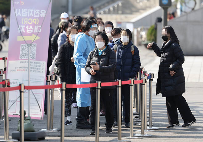 27일 오전 서울역 광장에 설치된 코로나19 임시선별 검사소를 찾은 시민들이 검사를 기다리고 있다. [연합뉴스]