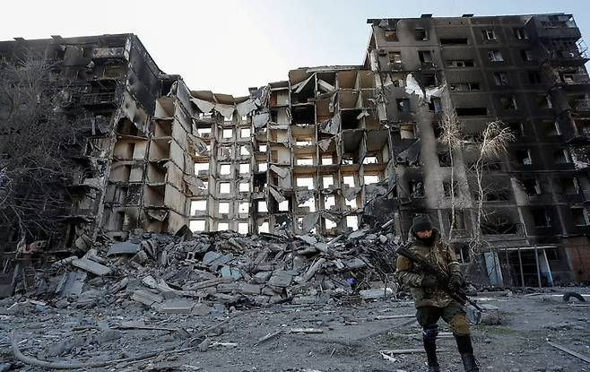 폐허가 된 우크라이나 남부 항구도시 마리우폴에 서 있는 군인의 모습. 로이터 연합뉴스