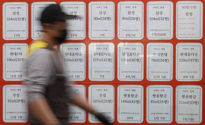 지난달 29일 오후 서울시내 한 부동산 중개업소 앞을 시민이 걸어가고 있다. [연합]