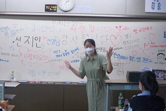 지난해 7월 임용시험 준비를 위해 기간제 교사로 근무하던 고등학교를 떠나게 될 당시 가르치던 학생들이 작별을 아쉬워하며 꾸며준 칠판 앞에서 신지인 교사가 고마움의 제스쳐를 취하고 있는 모습. [본인제공]
