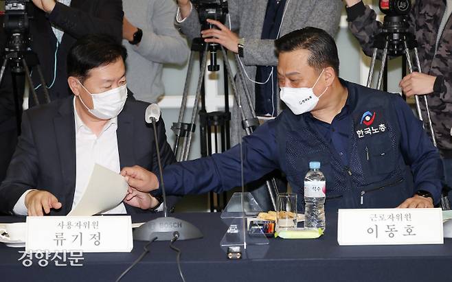 내년도 최저임금 결정을 위한 최저임금위원회 1차 전원회의가 5일 오후 서울 중구 한국프레스센터에서 열렸다. 노동자위원인 이동호 한국노총 사무총장(오른쪽)이 회의에 참석해 사용자위원인 류기정 한국경영자총협회 전무 자리에 놓인 회의자료를 전달받고 있다. 사진공동취재단