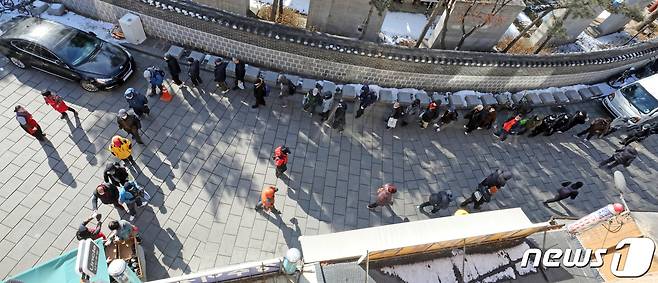 설 연휴 마지막 날인 2일 서울시 종로구 탑골공원 원각사 무료 급식소에서 어르신들이 점심식사를 받기 위해 줄을 서고 있다. 2022.2.2/뉴스1 © News1 장수영 기자