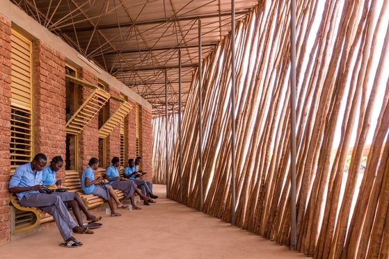 쇼게 중고등학교는 건물 밖에 나무 기둥을 설치해 강렬한 햇빛을 차단할 수 있게 했다.@ Francis Kéré