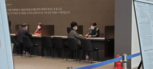 지난달 19일 서울 강동구 둔촌동 ‘둔촌주공아파트 재건축 사업’(올림픽파크 포레온) 견본주택에서 조합원들이 시공사업단 관계자들에게 최근 조합 집행부와 시공단 간 갈등 상황에 대한 설명을 듣고 있다. 이덕연 기자