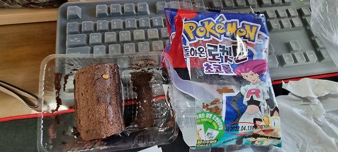 사진1. 제보자가 처음 SPC 고객센터에 신고한 사진. 초코롤 위에 주황색 애벌레가 붙어 있고 옆에는 유통기한이 11일까지로 표기된 해당 빵 봉지가 있다.