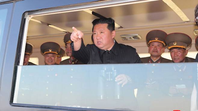 김정은 총비서가 지휘소에서 신형 미사일 발사 장면을 지켜보고 있다.